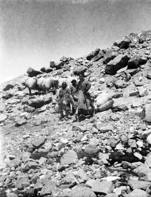 Armed Lattimore escort on donkey with two men standing by