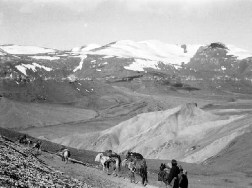 Descending pass, loaded horses with two men walking alongside