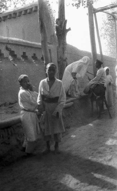 Two boys standing by a platform running alongside a wall