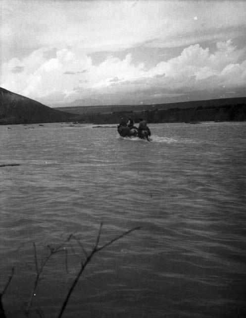 Horsemen fording river