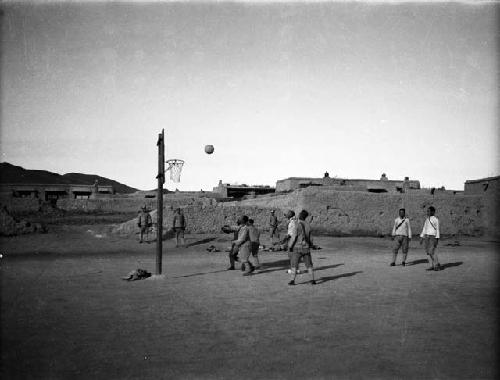 Gegenmiao, boys playing basketball, mud brick buildings in background