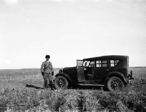 Escort standing next to care in vast plain, Gegenmiao trip