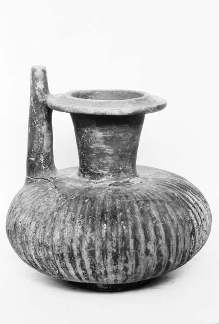 Corrugated jar with flaring neck, spout, and ring base, red, grave 4, number 27