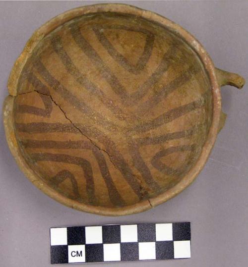 Restored red on brown cup with broken handle, interior triangular linear designs