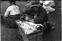 Man sitting on the ground with arms resting on a box