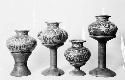 Four polychrome jars with flaring necks and four pot stands