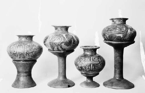 Four polychrome jars with flaring necks and four pot stands