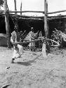 Making cart wheels near Aksu, two men working on a wheel