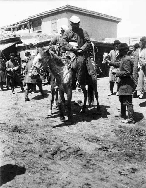 Men on ponies in bazaar, marketplace