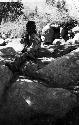 Caravan man, possible Ladakhi, sitting on boulders