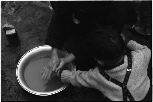 Adult washing a little boy's hand