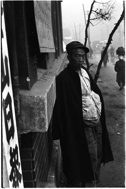 Man leaning against the side of a building