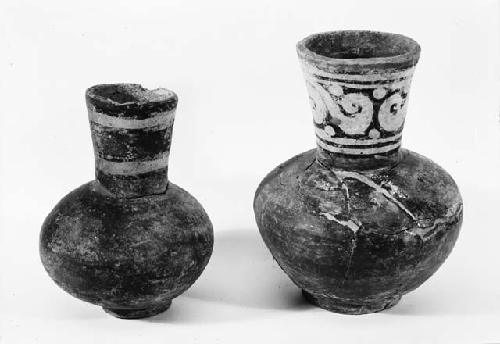 Two red carafes with ring bases and polychrome necks