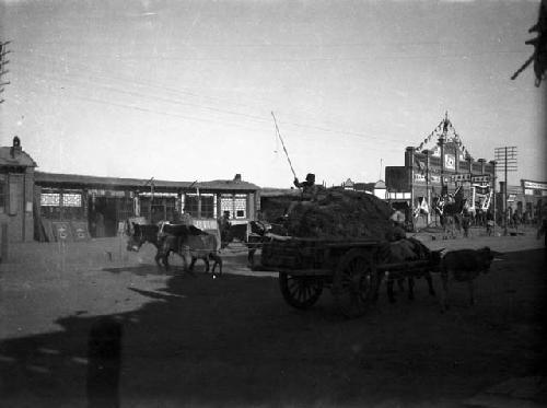 Paicheng-tze [Baicheng], cart in street with buildings in background