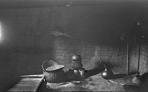 Hearth of hut with pots, baskets, gourds and other house goods