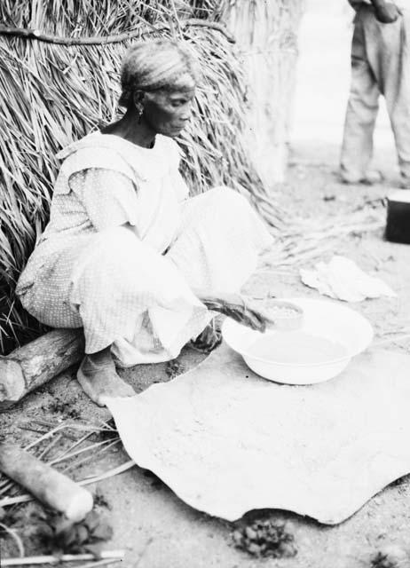Woman sifting beaten clay to make pottery