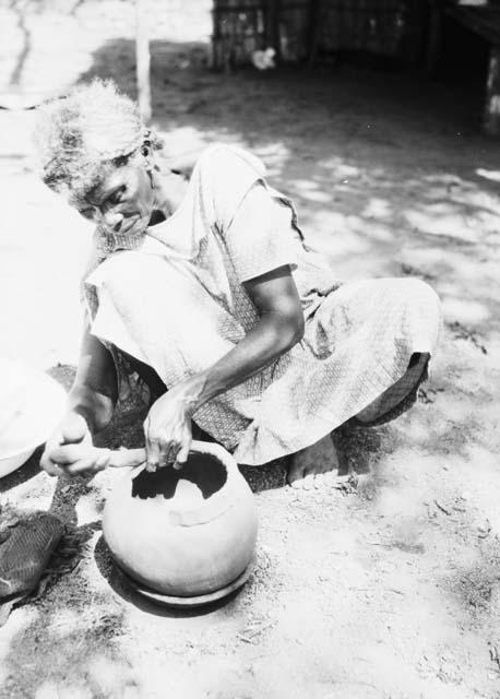 Pottery making, adding clay roll