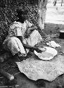 Woman sifting beaten clay to make pottery