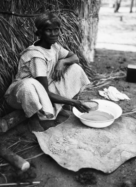 Woman sifting beaten clay to make pottery