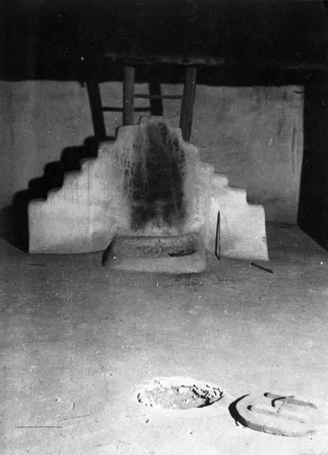 Interior of Kiva, terraced adobe with fire place in front of it