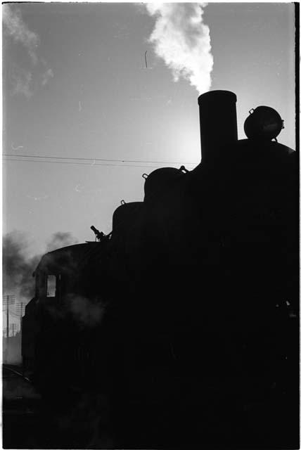 Silhouette of a train with steam coming out from the top