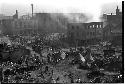 Bombed out city, people living in tents