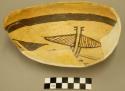 Fragments of black on yellow pottery bowl