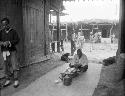 Man sitting on mat between two buildings