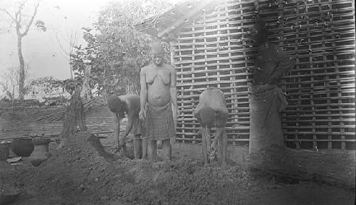 Hut construction process, People putting mud on hut