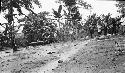 Men and boys dragging dugout canoe to the river