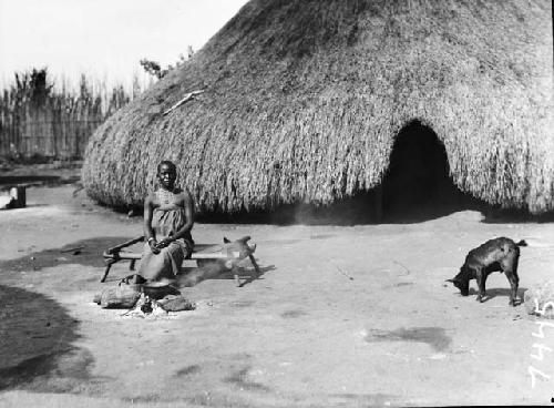 Woman sitting in behind open cooking fire