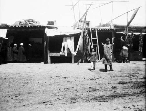 Kulja street man, boy in foreground, men in background with turbans