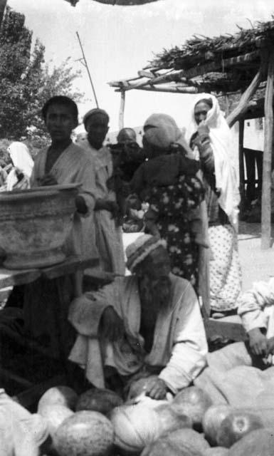 Town market, old man sitting in front of pile of melons