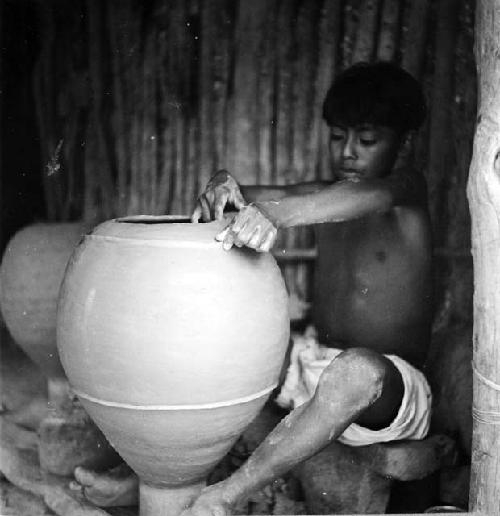 Ten-year-old son making a tinaja on a kabal