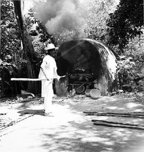 Macedonio Canul loading kiln with wood