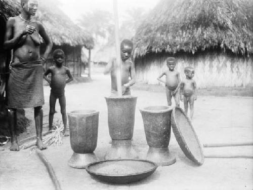 Woman and children hulling rice, Yopolo, Tcheripo or Kirepo clan