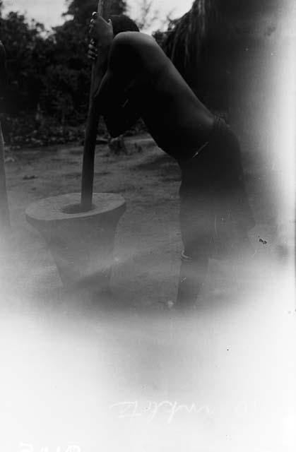 Woman in anklets using mortar and pestle