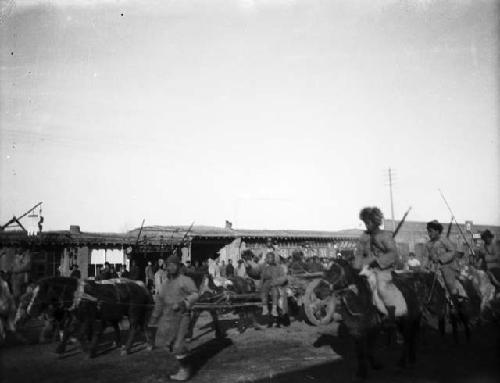 Captured bandits in carts with cavalry riding alongside