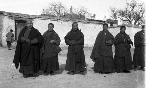 Seven monks standing in front of building, maybe temple