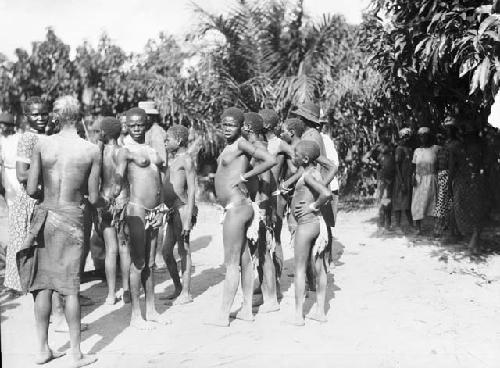 Crowd of men and women at dance in clearing