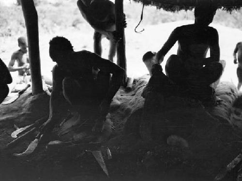 Smithy working under hut canopy