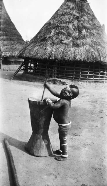 Young child learning to use mortar and pestle