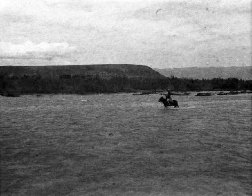 Horsemen fording river