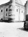 Mosque corner tower, base of minaret, man with boy standing in foreground