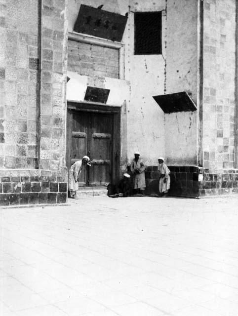 Doorway with Chinese inscriptions, four old men standing or sitting in entryway