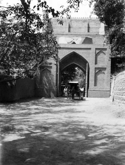 Cart coming through very large elaborate Kashgar gate with wooden doors