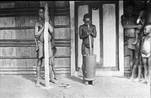 Children mashing plantains for supper