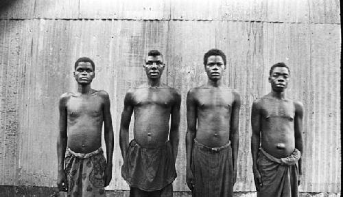 Front view of four men in front building