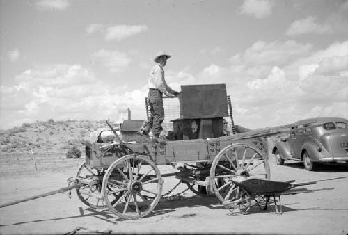 Elwood Dennis loading a stove on the wagon