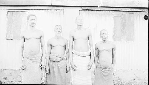 Front view of four men in front building